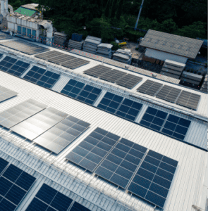 Industrielle Solarpanels auf dem Dach einer Fertigungsanlage, gewerbliche Solarinstallation und nachhaltige Energieversorgung in einer grünen Fabrik.