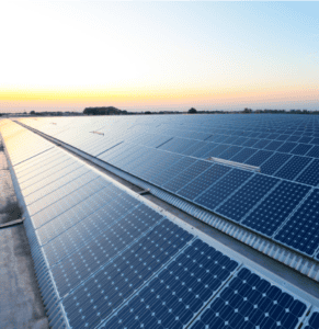 Großflächige gewerbliche Solarfarm mit Photovoltaik-Paneelen, die nachhaltige Stromerzeugung bei Sonnenuntergang ermöglichen.